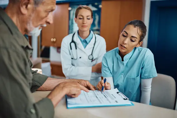 Picture of a woman helping an elderly man with his hospital appointment